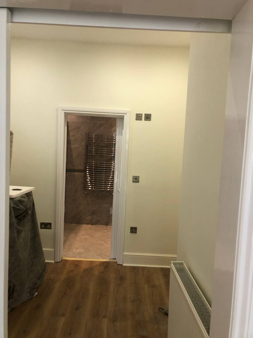 Freshly painted room with doorway to tiled bathroom — West London